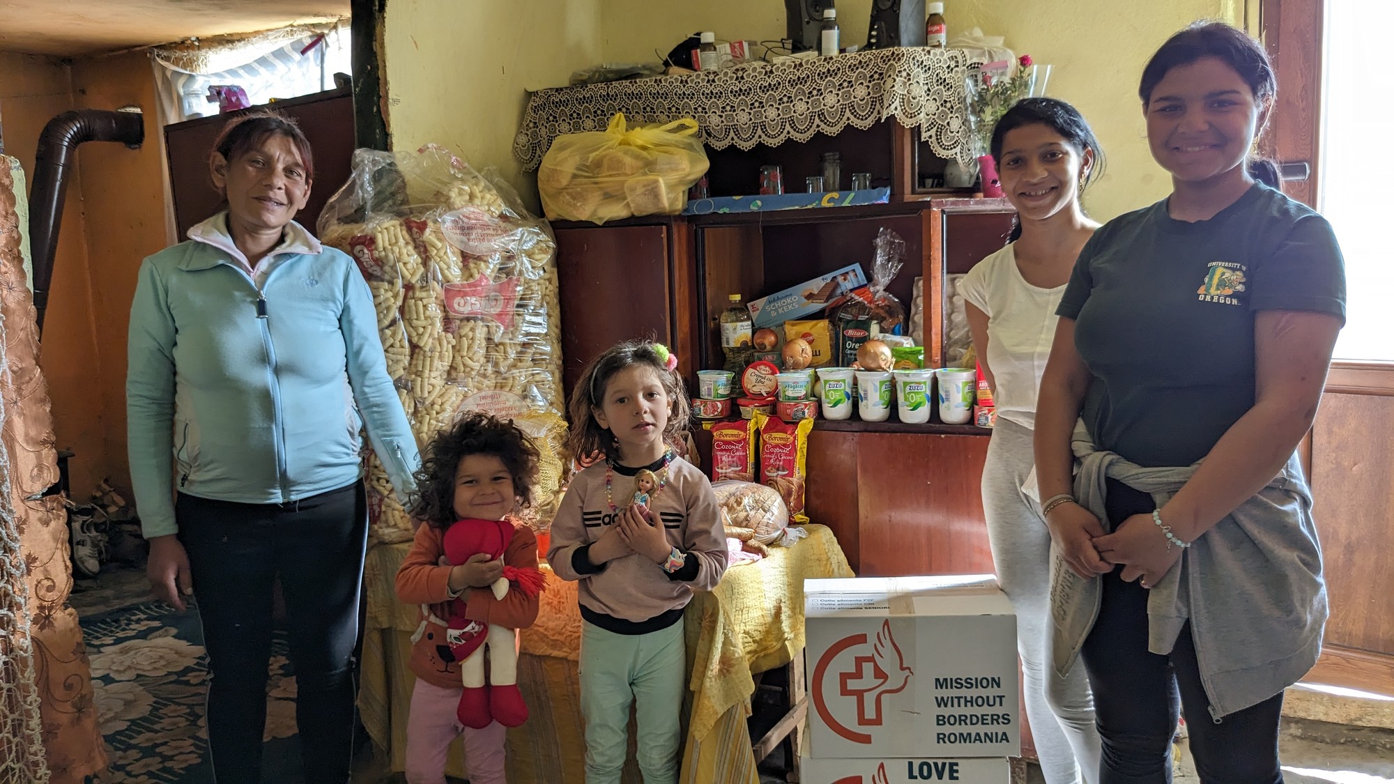 Stefana and her kids in front of full cupboards